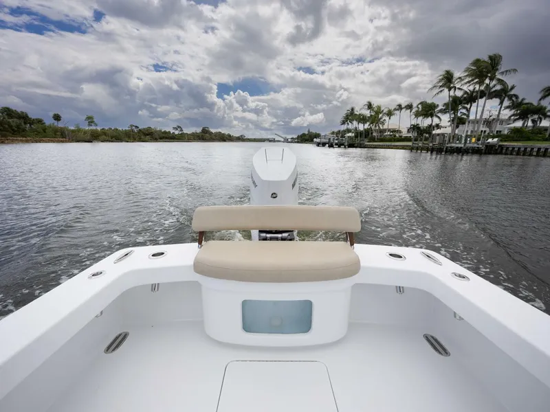 Slide: The Image of 2024 Xcelerator Boatworks 26 on a scenic waterway with palm trees and cloudy sky. - 30