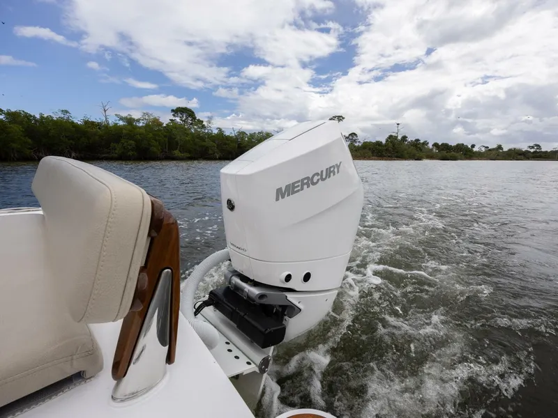 Slide: The Image of 2024 Xcelerator Boatworks 26 with Mercury outboard engine on a scenic waterway. - 34