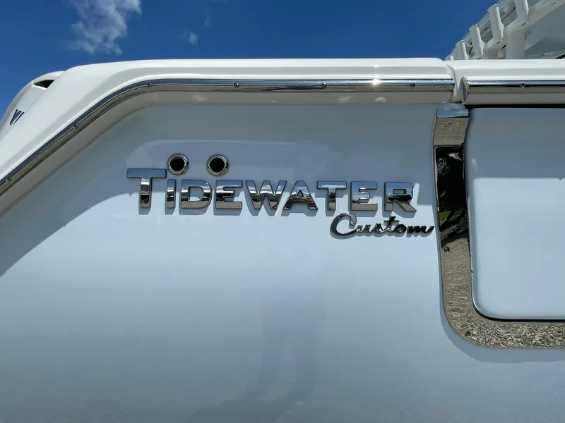 Slide: The Image of 2026 Tidewater 302 CC Adventure boat with custom branding under a clear blue sky. - 1
