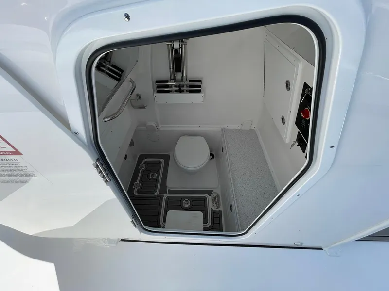 Slide: The Image of 2026 Tidewater 302 CC Adventure boat interior with compact marine toilet and storage. - 30