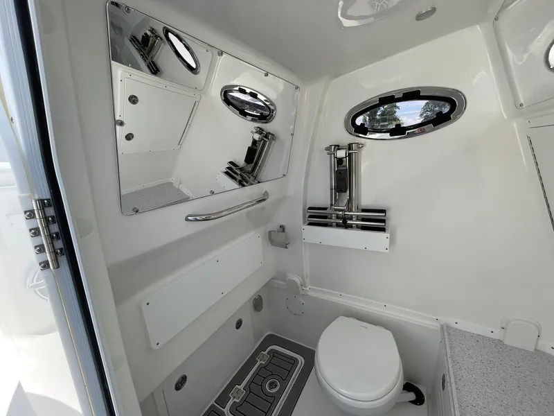 Slide: The Image of Interior of 2026 Tidewater 302 CC Adventure boat bathroom with modern fixtures and porthole windows. - 33