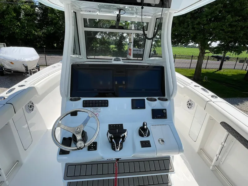 Slide: The Image of 2026 Tidewater 302 CC Adventure boat dashboard with steering wheel and navigation screens. - 34