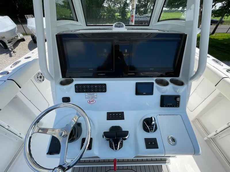 Slide: The Image of 2026 Tidewater 302 CC Adventure boat dashboard with dual screens and steering wheel. - 35