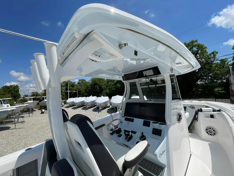 Slide: The Image of 2026 Tidewater 302 CC Adventure boat interior with modern helm and seating under clear blue sky. - 47
