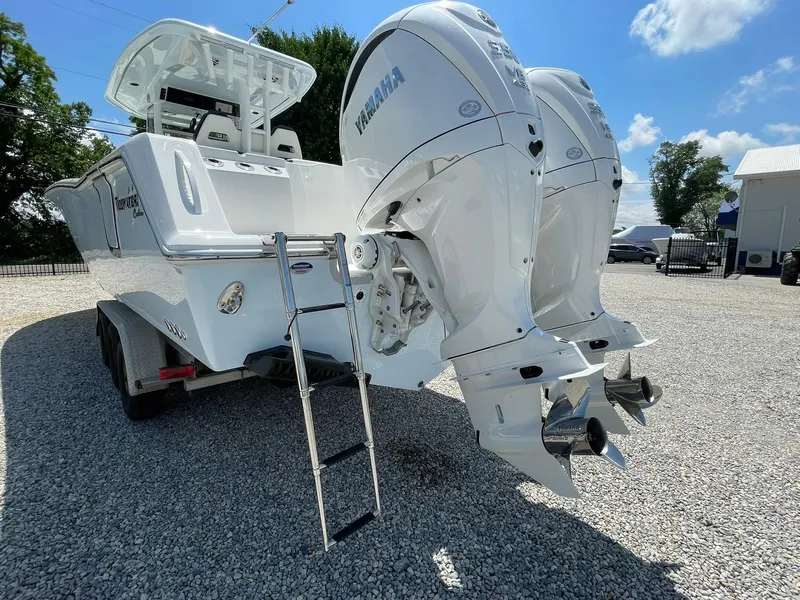 Slide: The Image of 2026 Tidewater 302 CC Adventure boat with dual Yamaha engines on a trailer. - 70