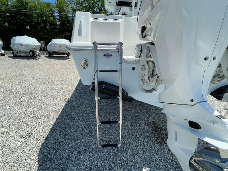 Slide: The Image of 2026 Tidewater 302 CC Adventure boat with ladder on gravel lot. - 71