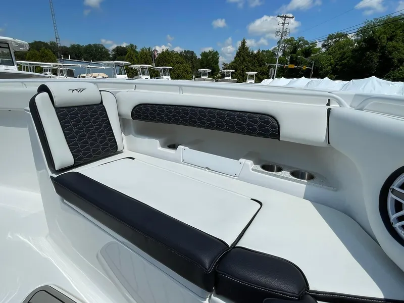 Slide: The Image of 2026 Tidewater 302 CC Adventure boat seating with black and white upholstery, cup holders, and speaker. - 9