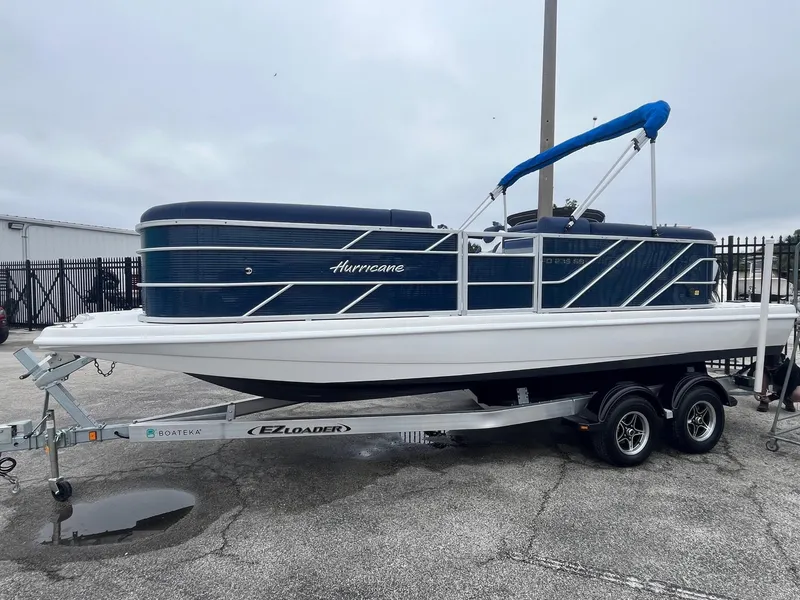Slide: The Image of 2021 Hurricane FD236 OB boat on EZ Loader trailer, parked outdoors. - 2