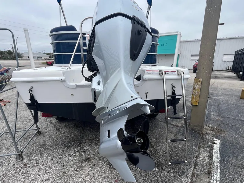 Slide: The Image of 2021 Hurricane FD236 OB boat with outboard motor and ladder, parked on gravel. - 3