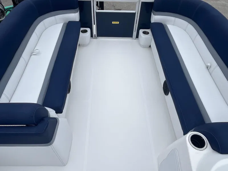 Slide: The Image of 2021 Hurricane FD236 OB boat interior with blue and white seating, cup holders, and spacious layout. - 4