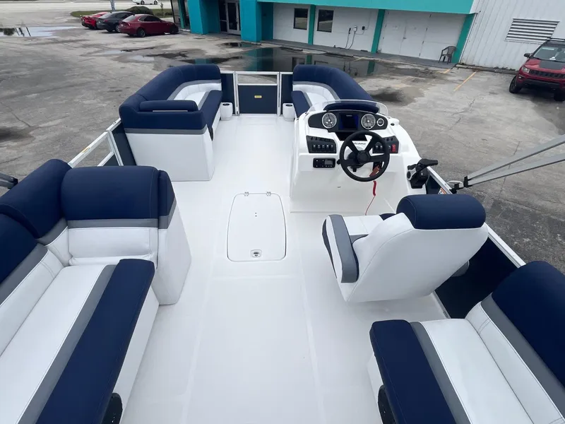 Slide: The Image of 2021 Hurricane FD236 OB boat interior with blue and white seating, steering console, and spacious layout. - 6