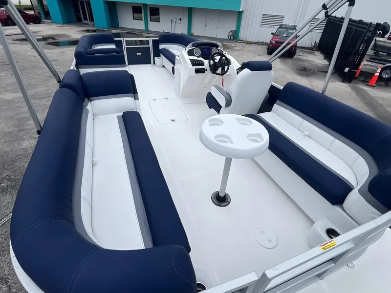 Slide: The Image of 2021 Hurricane FD236 OB boat interior with blue and white seating and a central table. - 7
