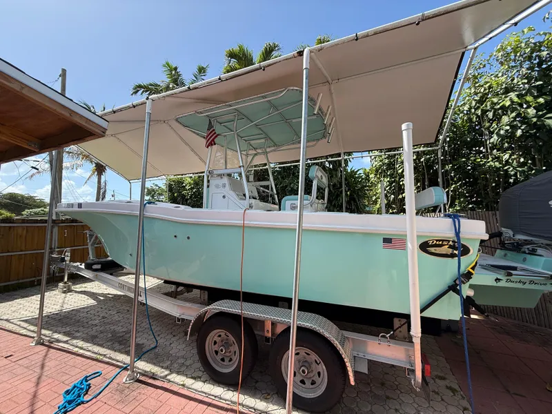 Slide: The Image of 2023 Dusky 252 boat on trailer under canopy, parked outdoors. - 10