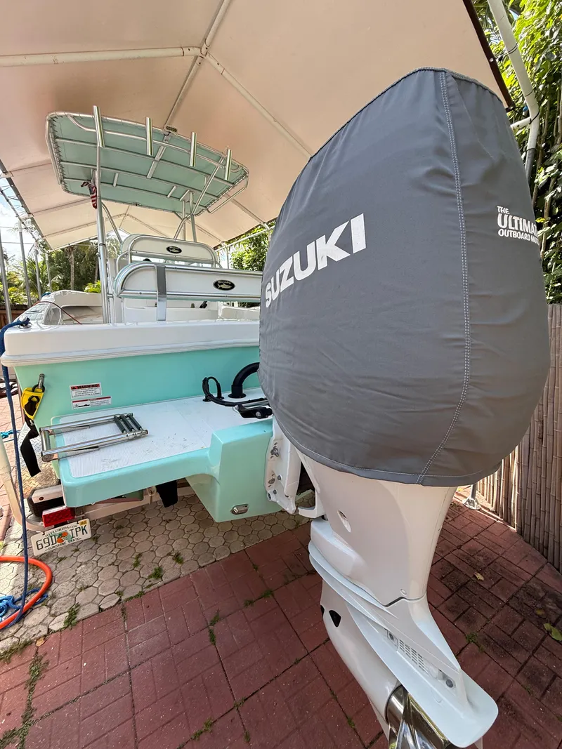 Slide: The Image of 2023 Dusky 252 boat with Suzuki outboard motor under canopy. - 12