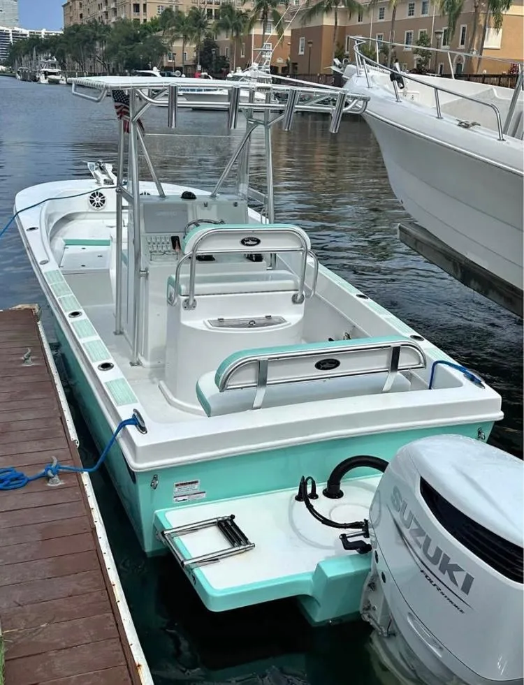 Slide: The Image of 2023 Dusky 252 boat docked, featuring a Suzuki outboard motor. - 2