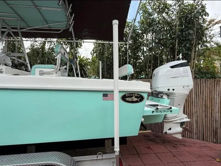 Slide: The Image of Dusky 252 boat, 2023 model, with outboard motor, parked on a trailer. - 4