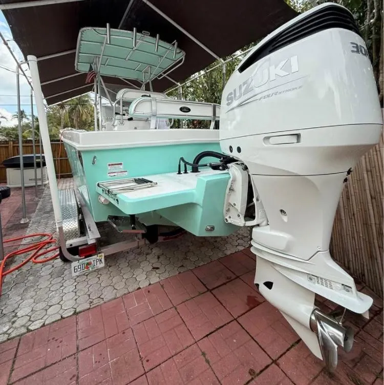 Slide: The Image of Dusky 252 boat with Suzuki engine, parked on a paved area, 2023 model. - 5