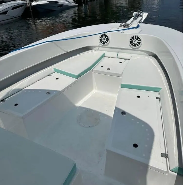 Slide: The Image of 2023 Dusky 252 boat interior with seating and storage, docked on calm water. - 8