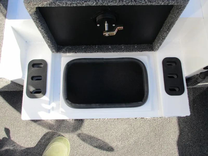 Slide: The Image of Vexus AVX 1980 2025 boat storage compartment with secure latch and carpeted interior. - 9