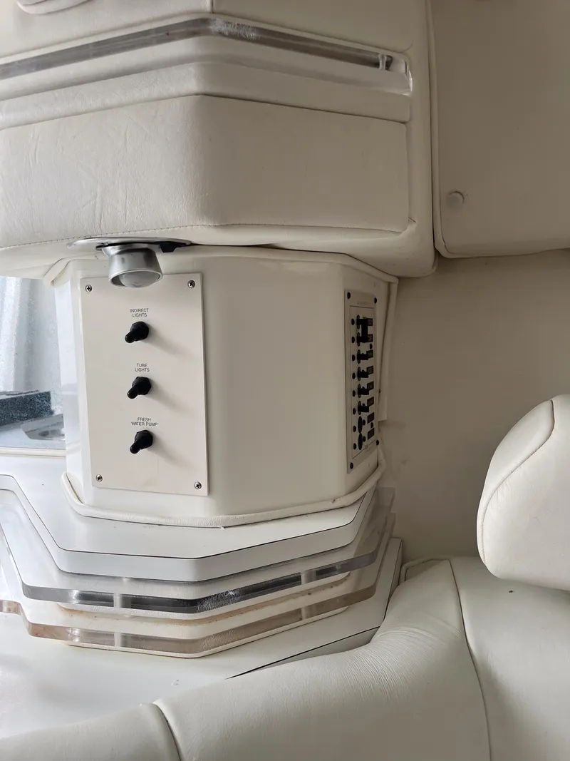 Slide: The Image of Interior of a 1998 Fountain 38 Fever boat, featuring white upholstery and control panel. - 12