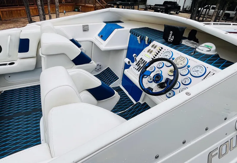 Slide: The Image of 1998 Fountain 38 Fever boat interior with white and blue seating, dashboard, and controls. - 7