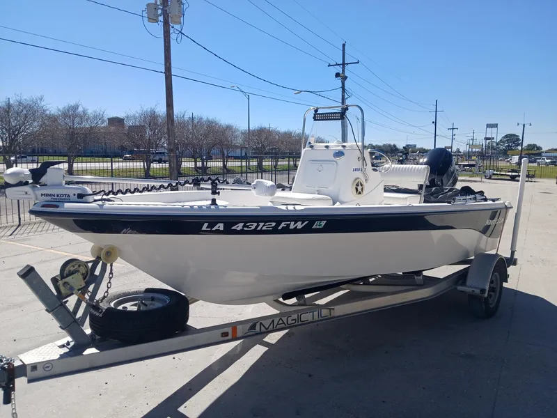 Slide: The Image of 2010 NauticStar 1810 boat on trailer, parked outdoors on a sunny day. - 12