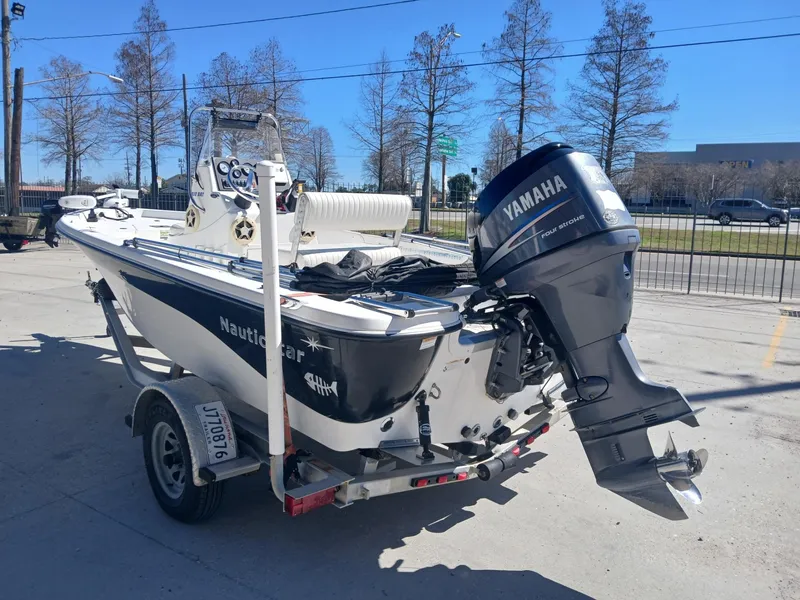 Slide: The Image of 2010 NauticStar 1810 boat with Yamaha outboard motor on a trailer. - 13