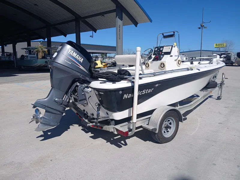 Slide: The Image of 2010 NauticStar 1810 boat with Yamaha outboard motor on a trailer. - 14