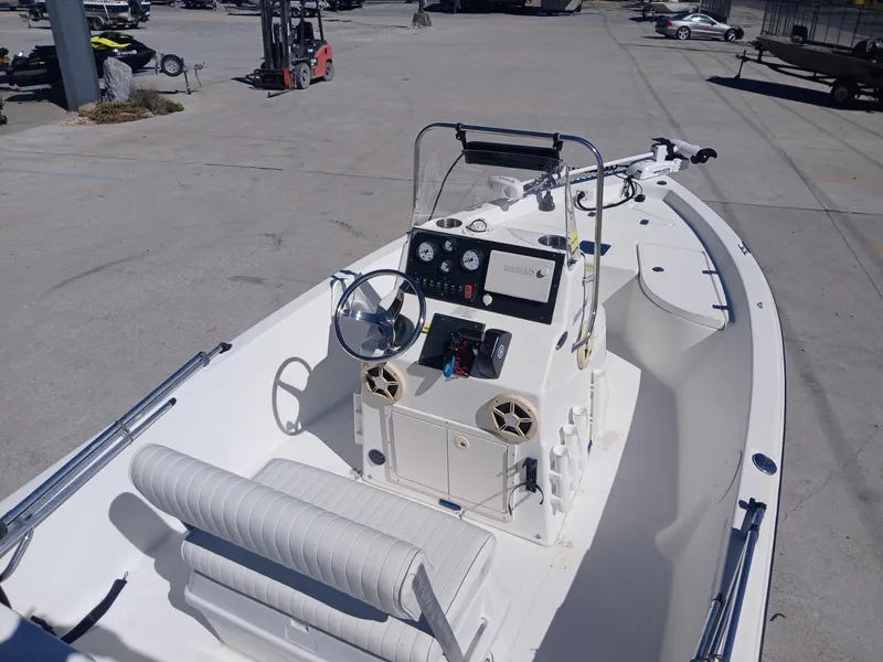 Slide: The Image of 2010 NauticStar 1810 boat with steering console and seating, parked in a marina. - 2