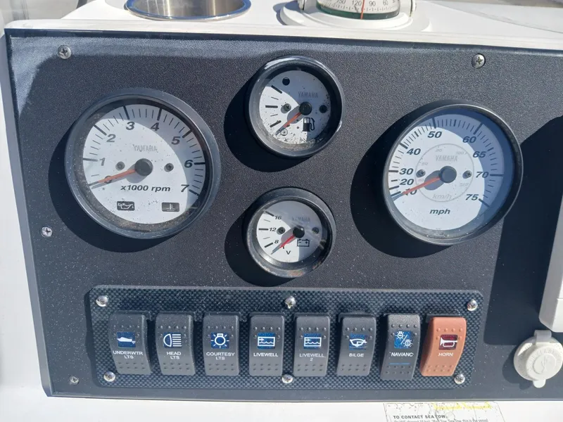 Slide: The Image of Control panel of a 2010 NauticStar 1810 boat with gauges and switches. - 5
