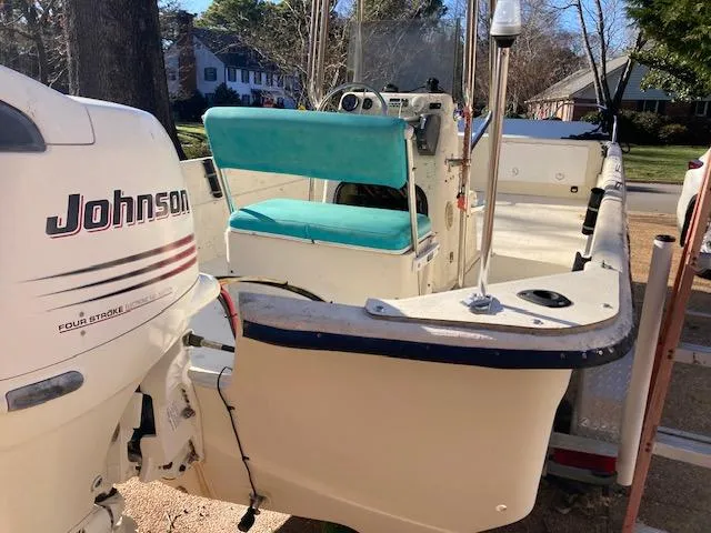 Slide: The Image of 1997 Carolina Skiff 198 DLV boat with Johnson outboard motor, parked on a trailer. - 3