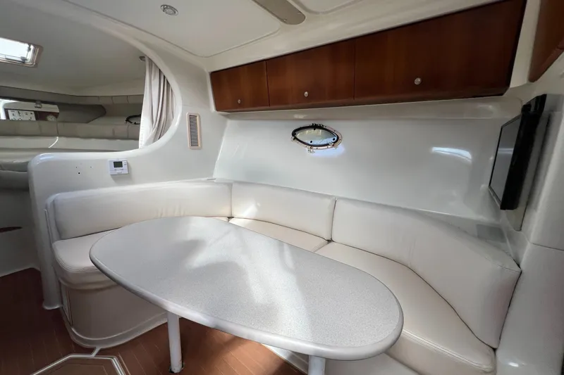 Slide: The Image of Interior of 1996 Silverton 310 Express yacht with white seating and wooden cabinets. - 16