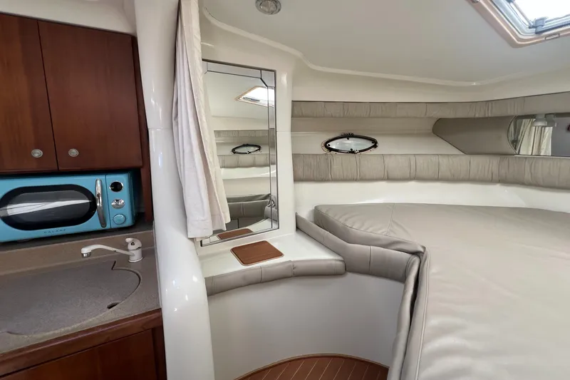 Slide: The Image of 1996 Silverton 310 Express cabin interior with kitchenette, bed, and porthole windows. - 17