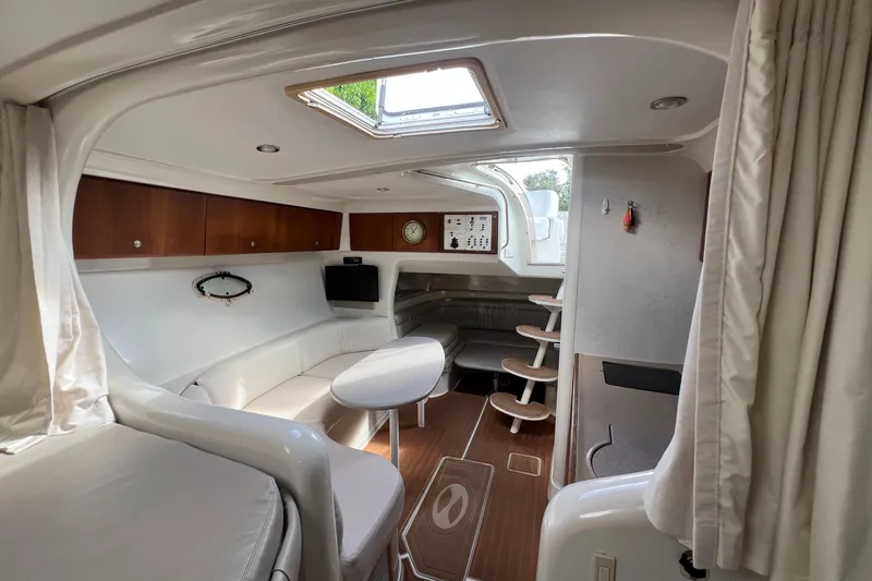 Slide: The Image of Interior of a 1996 Silverton 310 Express boat, featuring a cozy seating area. - 18