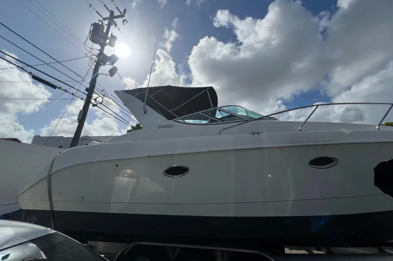 Slide: The Image of 1996 Silverton 310 Express boat under a cloudy sky, side view. - 2