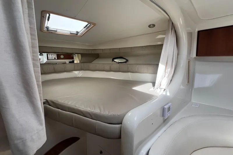Slide: The Image of 1996 Silverton 310 Express cabin interior with bed, window, and curtains. - 20