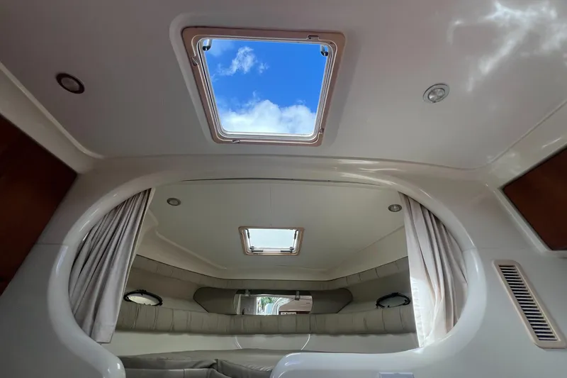 Slide: The Image of Interior cabin view of a 1996 Silverton 310 Express boat with skylight and curtains. - 22