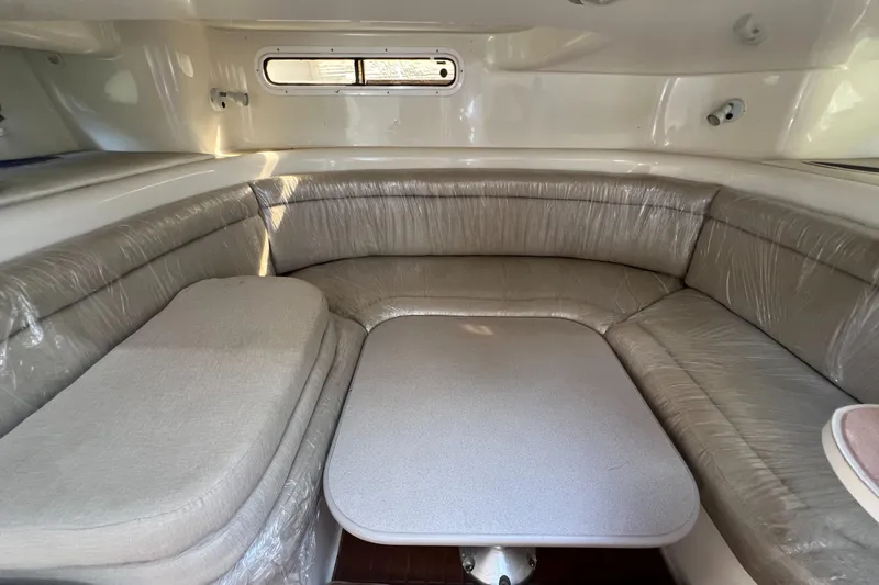Slide: The Image of 1996 Silverton 310 Express interior with cushioned seating and table. - 24