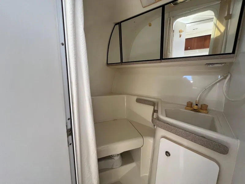 Slide: The Image of 1996 Silverton 310 Express boat bathroom with sink, mirror, and storage cabinet. - 26