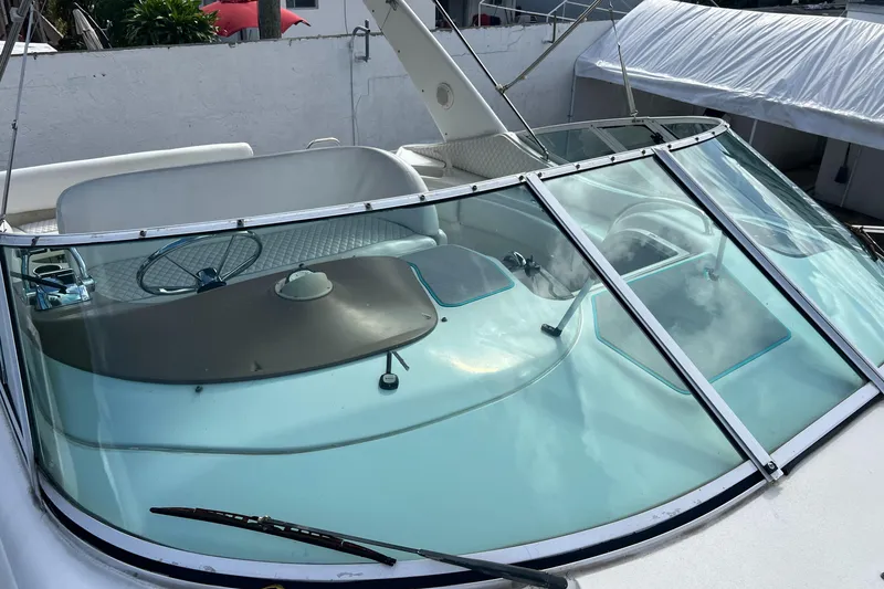 Slide: The Image of 1996 Silverton 310 Express boat with sleek windshield and helm, docked in marina. - 30
