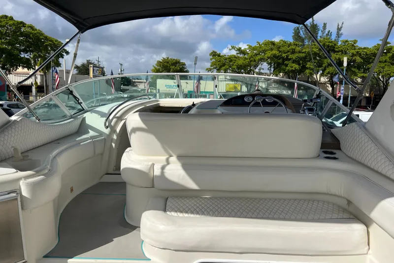 Slide: The Image of 1996 Silverton 310 Express boat interior with white seating and canopy. - 32