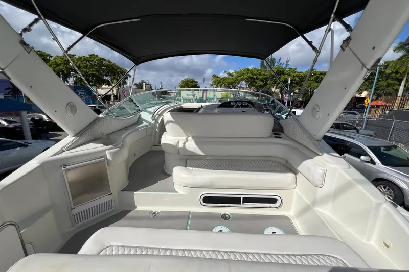 Slide: The Image of 1996 Silverton 310 Express boat interior with seating and canopy, parked outdoors. - 5