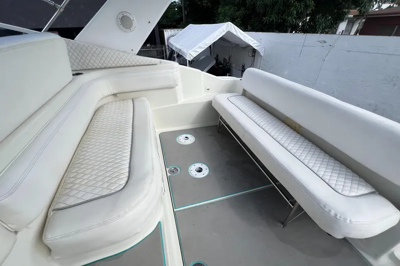 Slide: The Image of 1996 Silverton 310 Express boat interior with white cushioned seating. - 8