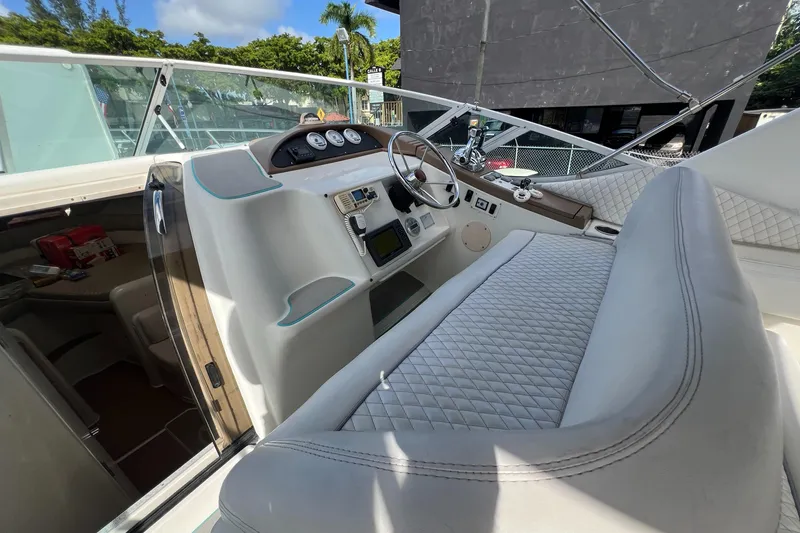 Slide: The Image of 1996 Silverton 310 Express boat interior with white seating and modern dashboard. - 9