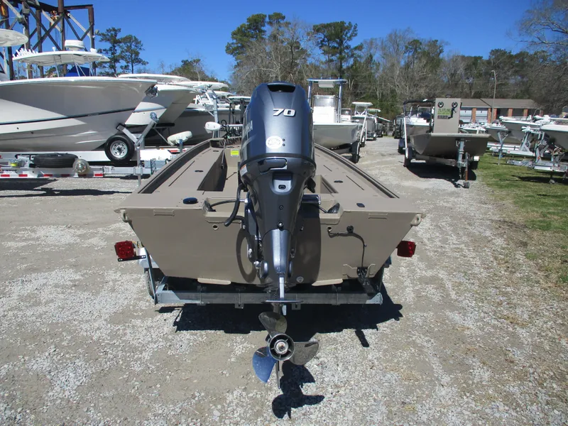 Slide: The Image of 2025 Alweld 1752PF boat with outboard motor, parked on a trailer in a boatyard. - 2