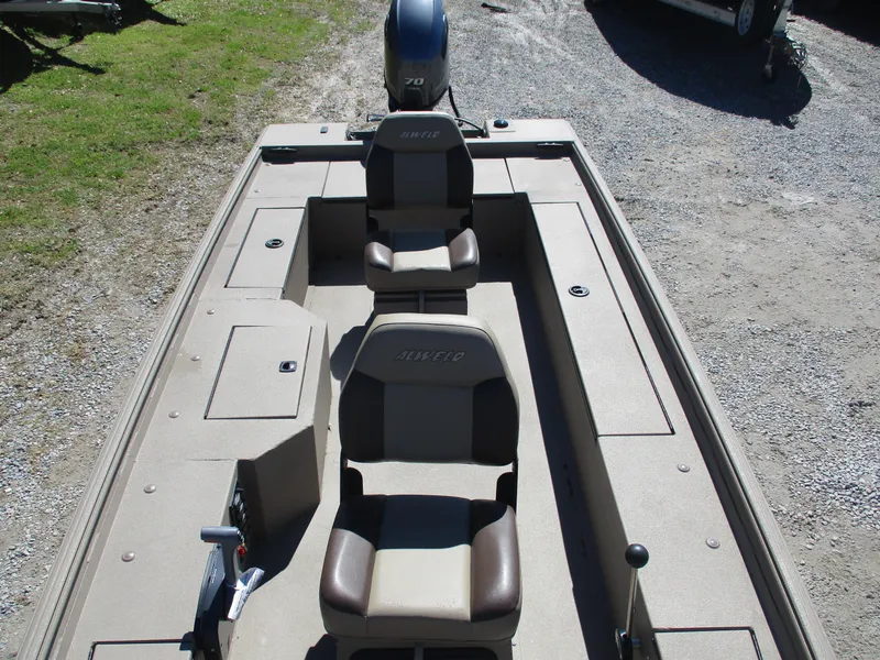 Slide: The Image of 2025 Alweld 1752PF boat interior with two seats and motor, parked on gravel. - 5