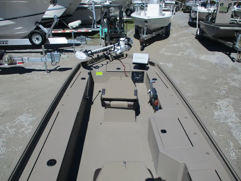 Slide: The Image of 2025 Alweld 1752PF boat, beige interior, parked among other boats on gravel. - 8