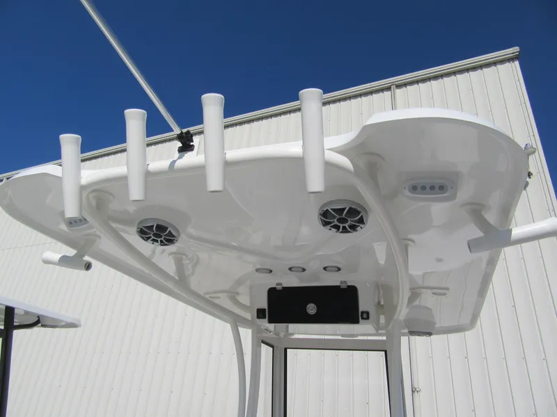 Slide: The Image of 2025 Parker 2200 Center Console boat's T-top with rod holders and speakers against blue sky. - 6