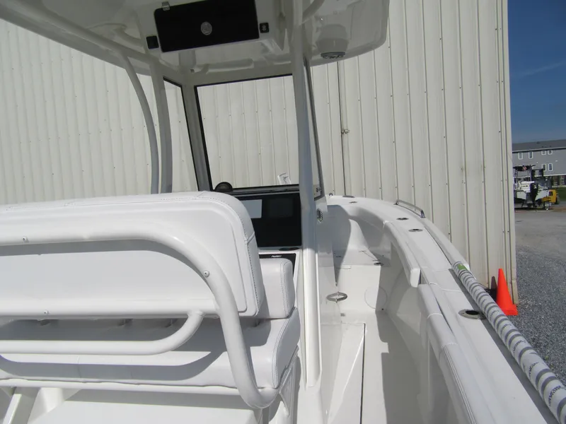 Slide: The Image of 2025 Parker 2200 Center Console boat, white interior, docked near a building. - 7