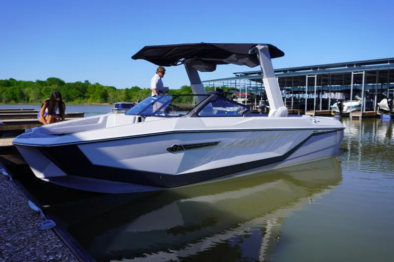 Slide: The Image of 2025 Nautique Super Air Nautique G25 boat docked on a sunny day. - 0